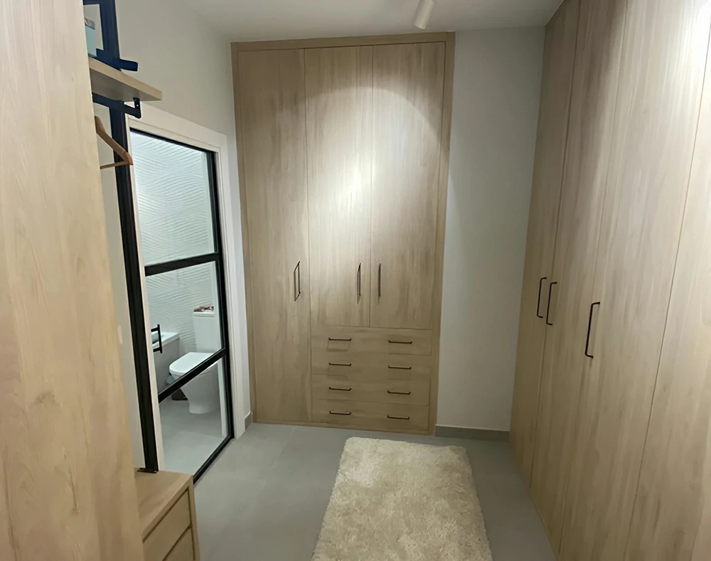Vestidor compuesto por armarios de puertas batientes y cajones vistos